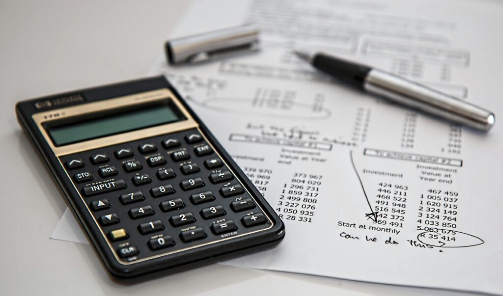 Close-up of financial documents with calculator and pen, ideal for business management themes.