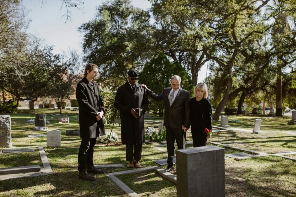 A solemn funeral gathering in a cemetery, capturing an emotional moment of remembrance.